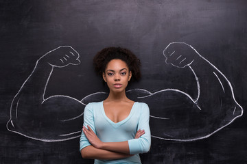 Serious afro-american woman with painted muscular arms on