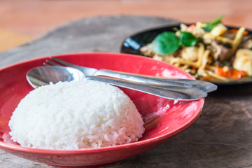 rice in red disk on wood background