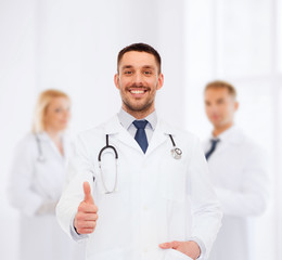 Fototapeta premium smiling doctor with stethoscope showing thumbs up