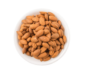 Raw almond nut in a white bowl over white background