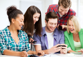 Fototapeta na wymiar students looking at smartphone at school