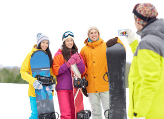 happy friends with snowboards and smartphone