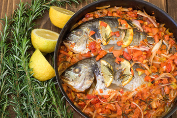 Baked fish with vegetables and rosemary.