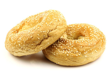 freshly baked bagel and a cut one on a white background