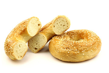 freshly baked bagel and a cut one on a white background
