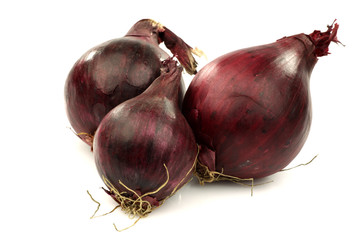 three red onions on a white background