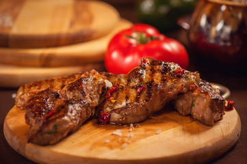 Мясо-гриль на доске с помидором