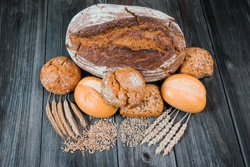 Backwaren - Brot, Brötchen und Getreide auf altem Holztisch