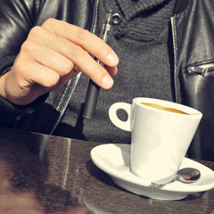 young man with an electronic cigarette and a cup of coffee in th
