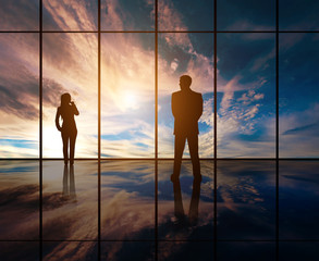 Fototapeta na wymiar Silhouettes of businesspeople standing against panoramic window