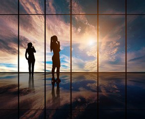 Fototapeta na wymiar Silhouettes of businesspeople standing against panoramic window