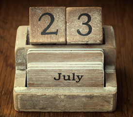 A very old wooden vintage calendar showing the date 23rd July on