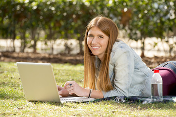 happy student girl on grass with computer internet studying