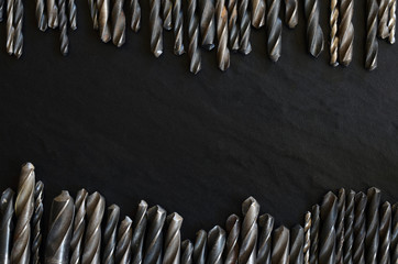 Set of old, worn drill bits on a dark table