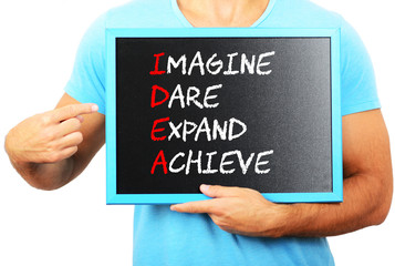 Man holding blackboard in hands and pointing the word IDEA