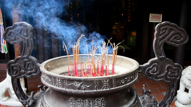 Incense Sticks Burning in Giant Pot in Front of Buddhist Temple 