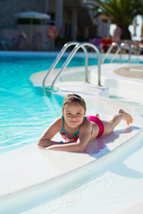 Smiling little girl relaxing in the swimming pool.