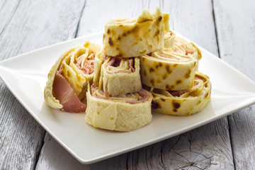 Roll of piadina with ham and cheese