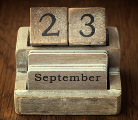 A very old wooden vintage calendar showing the date 23rd Septemb