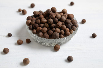 Whole allspice peppers on a white table