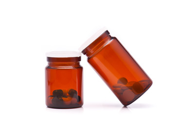 Pills pouring out of the brown bottle