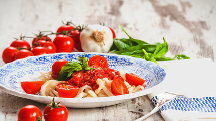 Healthy plate of Italian spaghetti topped with a tasty tomato an