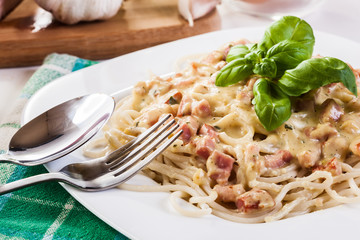 Spaghetti carbonara with bacon and basil