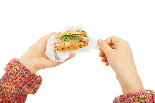 Sandwich with salami and cheese in hands