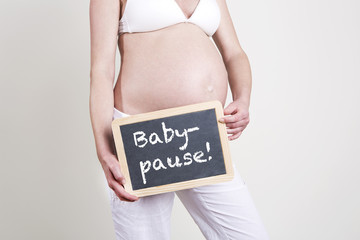 Pregnant woman with an empty blackboard