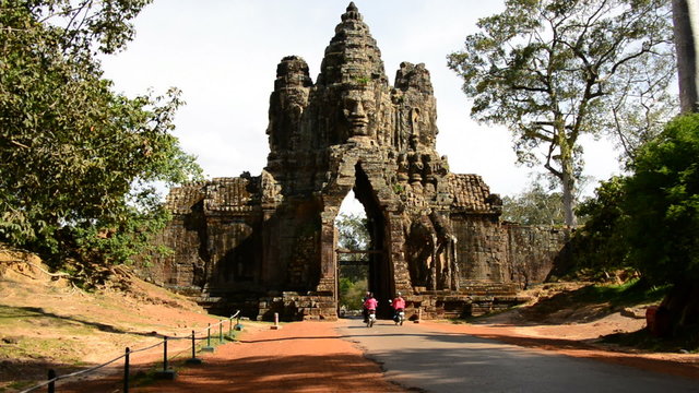 Mopeds Drive through Ancient Archway on Bridge - Angkor Wat Cambodia