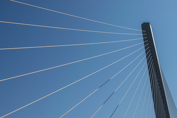 Fragment of a modern cable stayed bridge on the sky background.