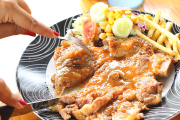 Steaks, french fries with vegetables salad on a plate.