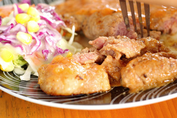 Steaks, french fries with vegetables salad on a plate.