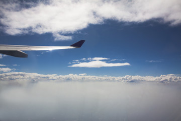 Obraz na płótnie Canvas Clouds and sky as seen through window of an aircraft.