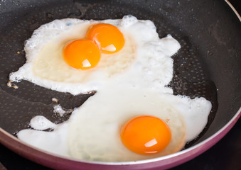 Close-up photo of two scrambled eggs in  pan