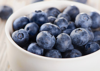 Fresh Blueberries in a white bowl .
