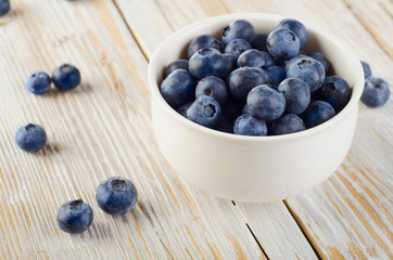 Blueberries in a bowl on  wooden table.