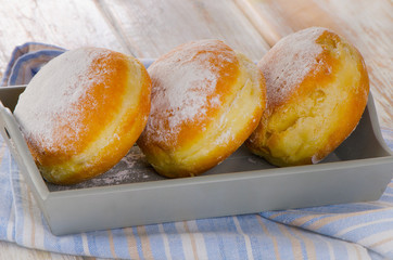 Homemade Donuts with powdered sugar in  a wooden box.