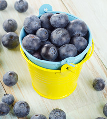 Blueberries in  buckets on a wooden table.
