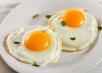 Fotobehang Spiegeleieren Twee gebakken eieren op witte plaat voor gezond ontbijt