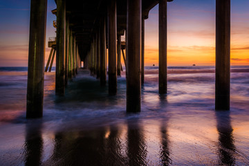 Under the pier at sunset, in Huntington Beach, California.