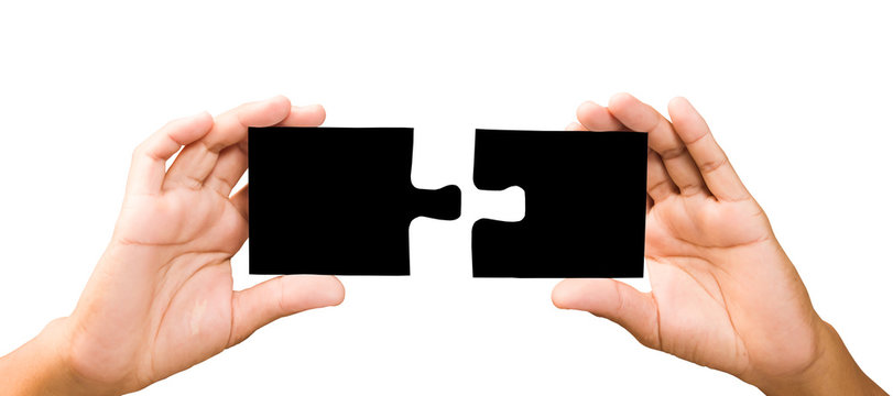 connection concept. hands with pieces of black puzzle.