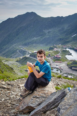 Teenage hiker resting on a rock