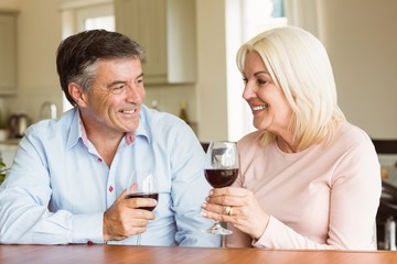 Happy mature couple drinking red wine