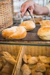 Hand of waiter taking bread with tongs
