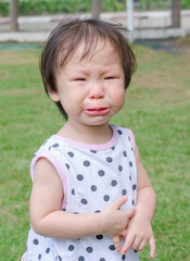 Little Asian girl crying in park