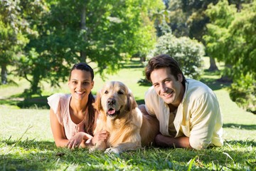 Happy couple with their dog in the park