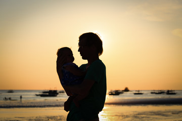 Father and little daughter silhouettes on beach