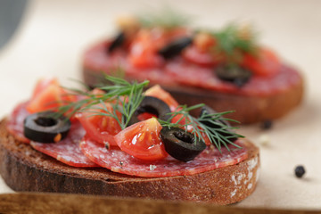 open rye sandwich with salami and vegetables