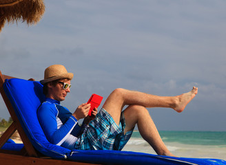 man with touch pad on beach vacation